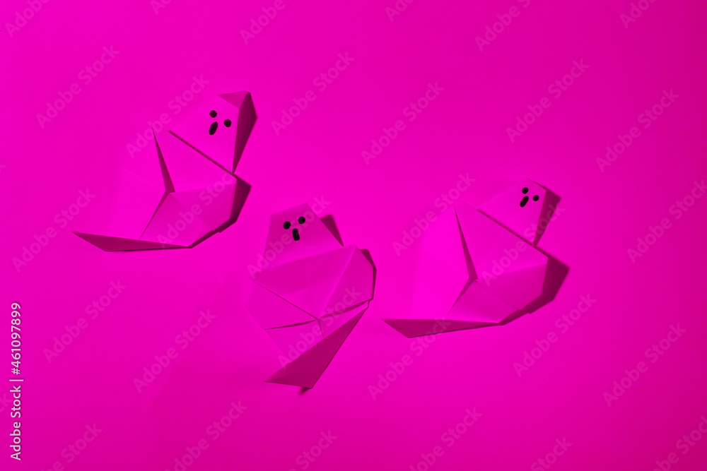 Origami ghosts in pink neon light. Halloween theme Origami ghosts in pink neon light. Halloween theme