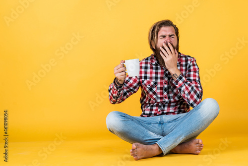 yawning sleepy tired guy. he is taking a coffee break. Handsome mature guy drinking from cup. Hold cup of coffee or tea. lifestyle concept. handsome hipster man with cup of coffee © be free