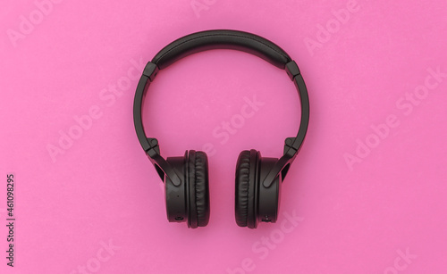 Wireless stereo headphones on pink background. Top view