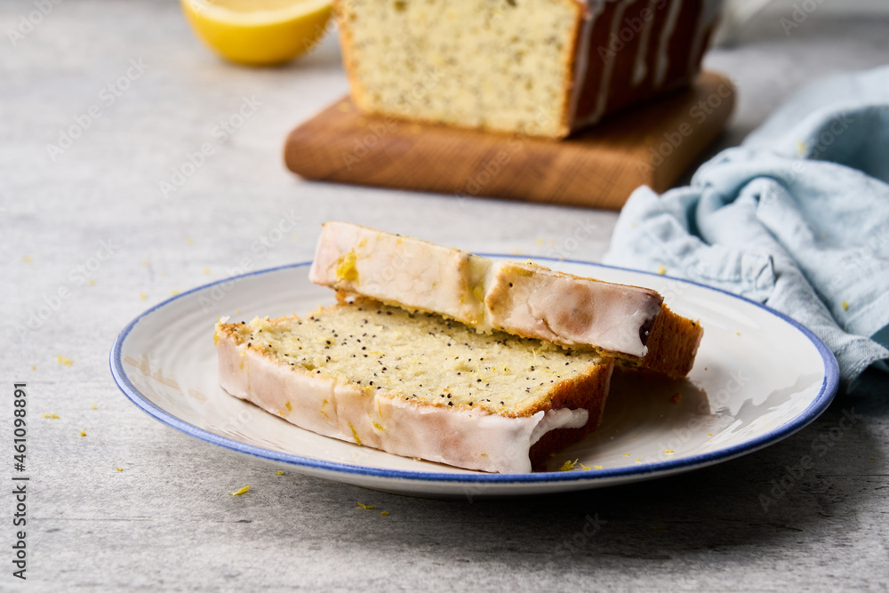 Delicious white icing lemon fruitcake with poppy seeds and orange peel served on plate. Healthy and vegetarian homemade sweet bakery. Side view, closeup, horizontal Delicious white icing lemon fruitcake with poppy seeds and orange peel served on plate. Healthy and vegetarian homemade sweet bakery. Side view, closeup, horizontal