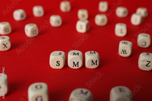 Wooden cubes with abbreviation SMM  Social media marketing  on red background