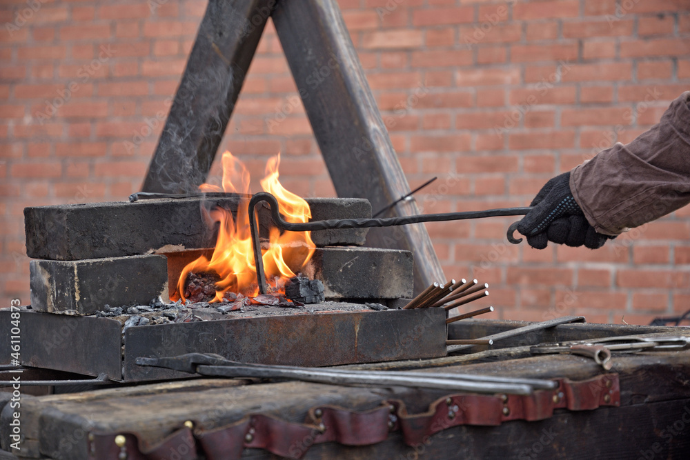 blacksmiths work with metal, heating it in a fire.