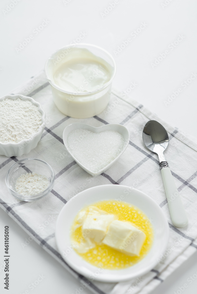 Ingredients set for baking, serving on towel. Cooking pie, cake, pancakes. Flour, eggs, sugar, butter for sweet pastries on white background. Culinary light composition Ingredients set for baking, serving on towel. Cooking pie, cake, pancakes. Flour, eggs, sugar, butter for sweet pastries on white background. Culinary light composition