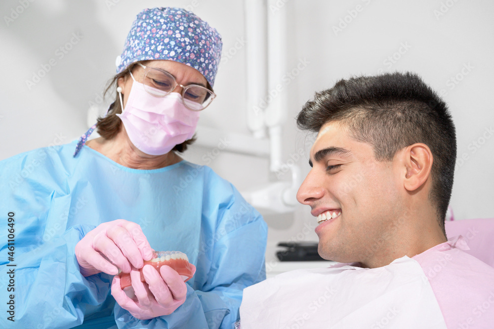 Orthodontist holding invisible retainer for teeth alignment. In clinic shows patient removable transparent plastic aligners or invisalign use and benefit. High quality photo. Orthodontist holding invisible retainer for teeth alignment. In clinic shows patient removable transparent plastic aligners or invisalign use and benefit. High quality photo.