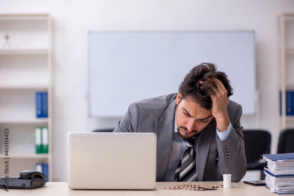 Young businessman employee suffering at workplace