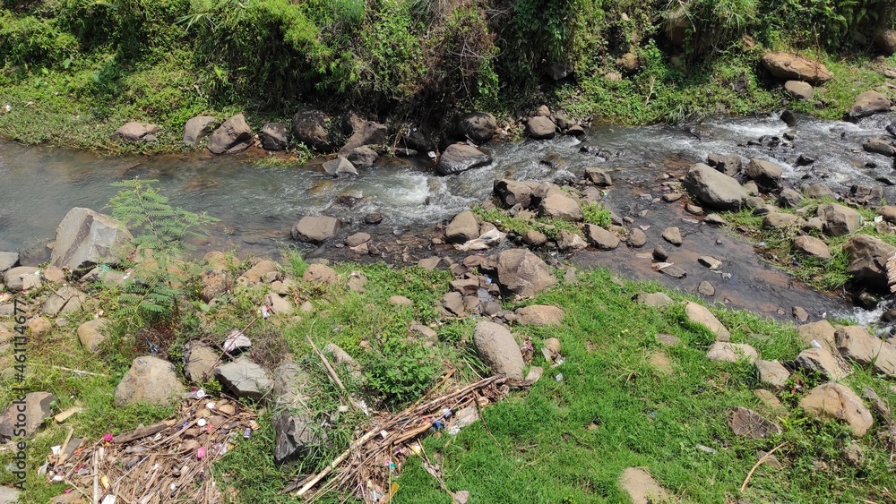 Photo of a small river on a hillside surrounded by rice fields and trees in the Cicalengka area, Indonesia Photo of a small river on a hillside surrounded by rice fields and trees in the Cicalengka area, Indonesia