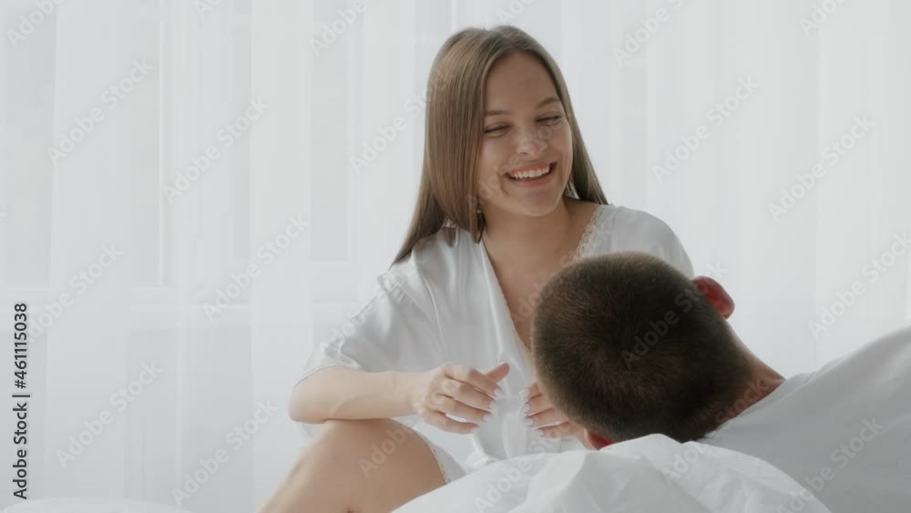 Young Romantic Couple Spending Time In Bedroom Together, Chatting And Laughing Young Romantic Couple Spending Time In Bedroom Together, Chatting And Laughing