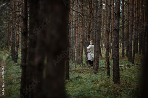 a girl in a white sweater walks in the autumn forest