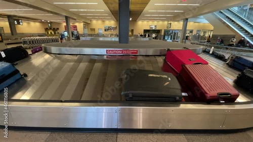 man grabbing bag off baggage carousel at luggage claim in airport
