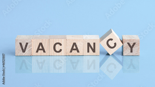 vacancy sign made of blocks on a table with a reflective surface, blue background