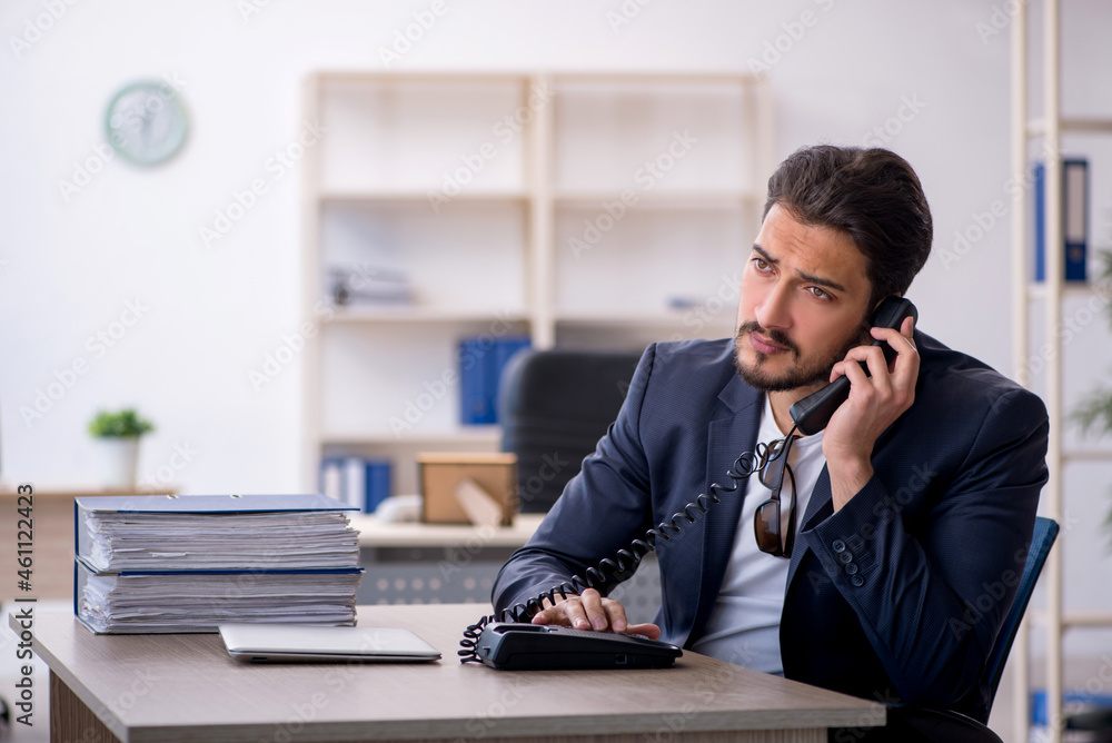Young handsome employee working in the office Young handsome employee working in the office