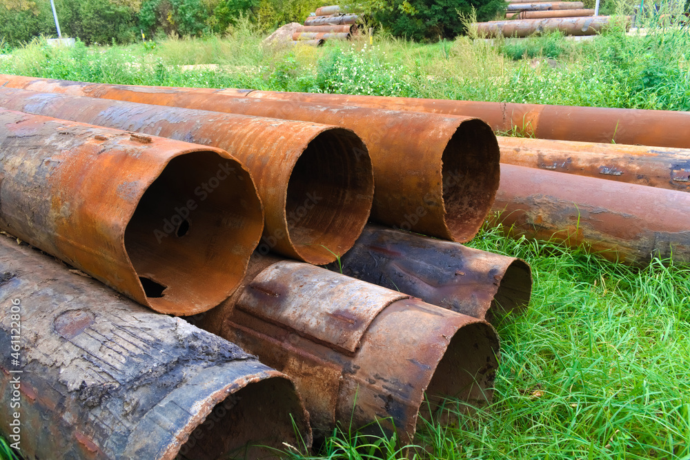 Stacked rusty metal pipelines in construction site