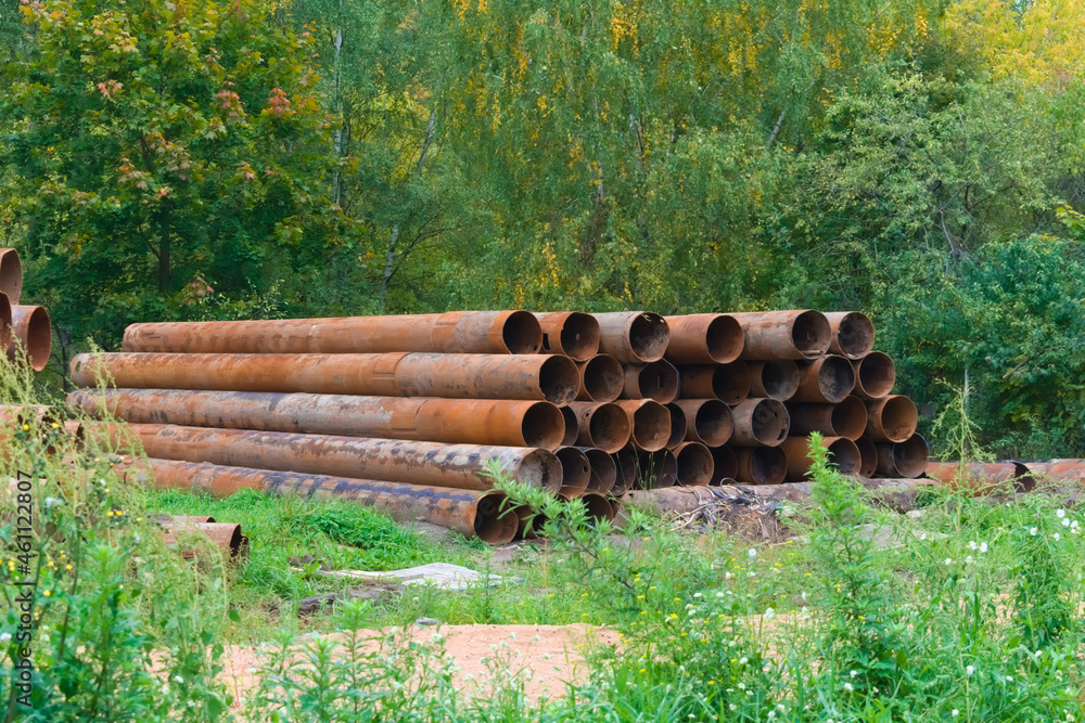 Stacked rusty metal pipelines in construction site
