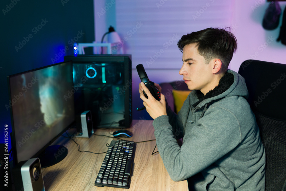 Young man putting on headphones to play videogames Young man putting on headphones to play videogames