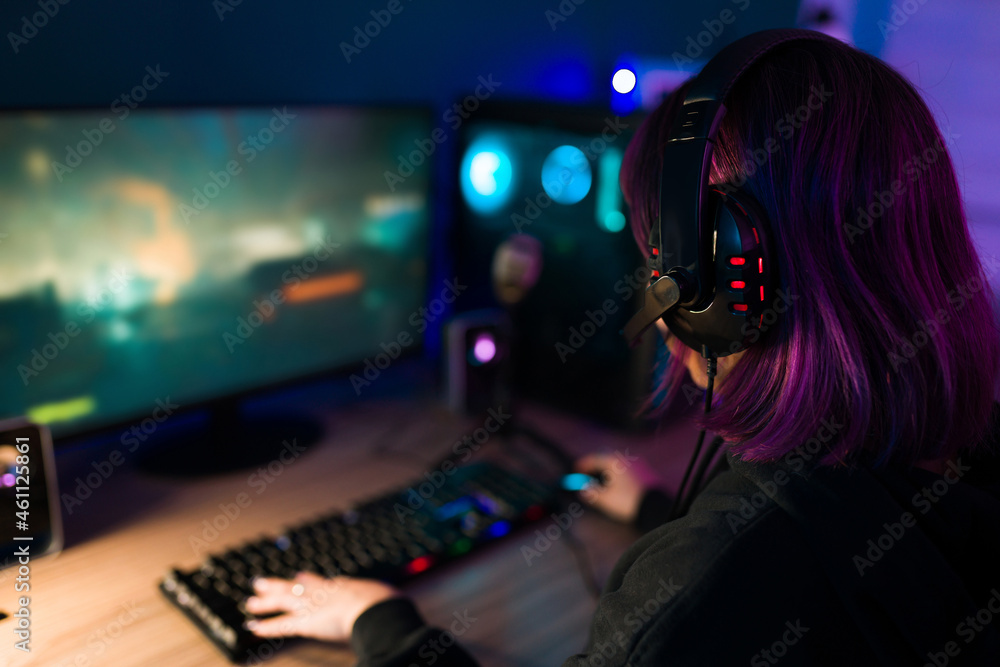 Rear view of a female gamer with purple hair Rear view of a female gamer with purple hair
