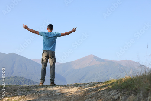 Man enjoying picturesque mountain landscape, back view. Space for text