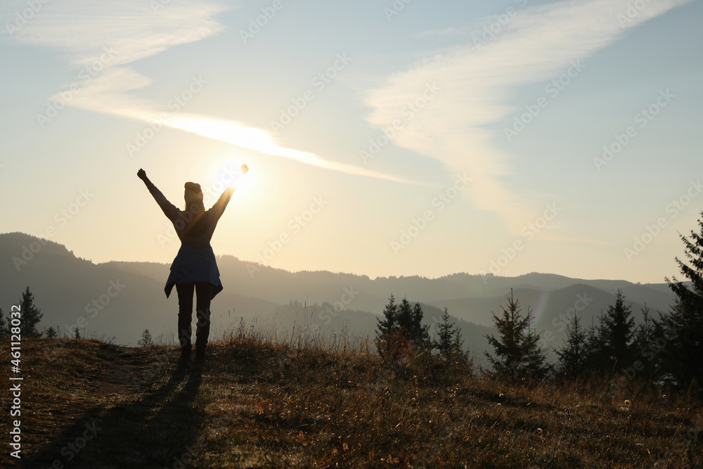 Woman enjoying sunrise in mountains, back view. Space for text Woman enjoying sunrise in mountains, back view. Space for text