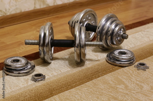Metal collapsible dumbbells on the carpet