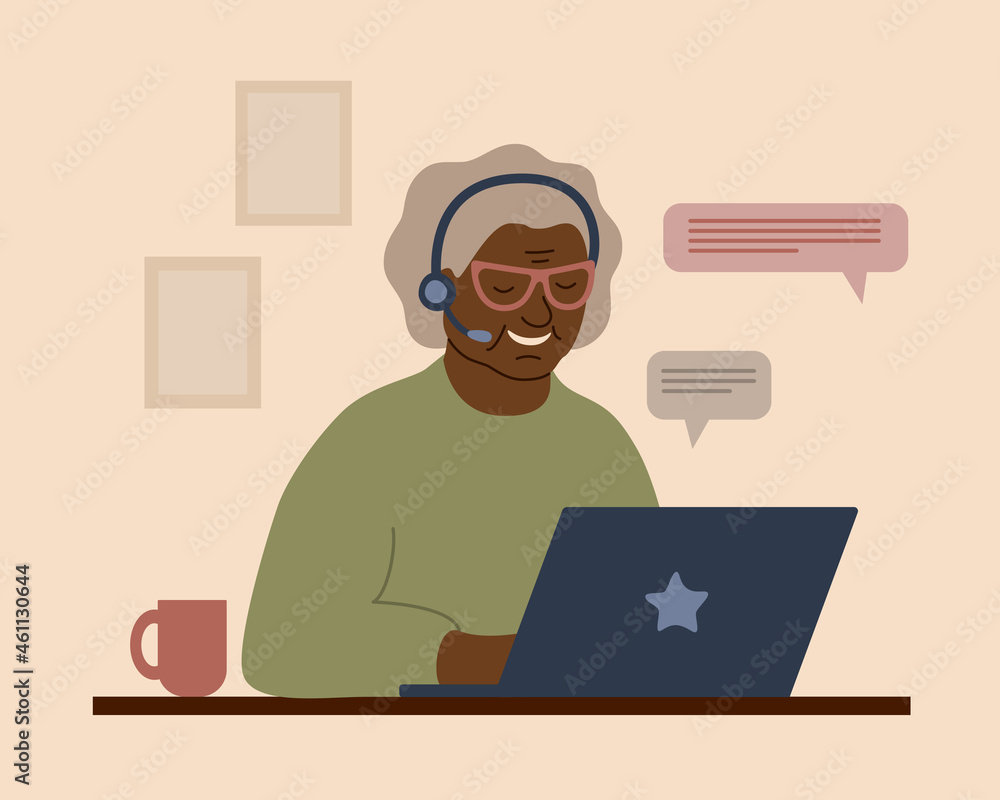 A smiling African grandmother in headphones with a laptop. An elderly woman communicates, studies, works or shoppes online.