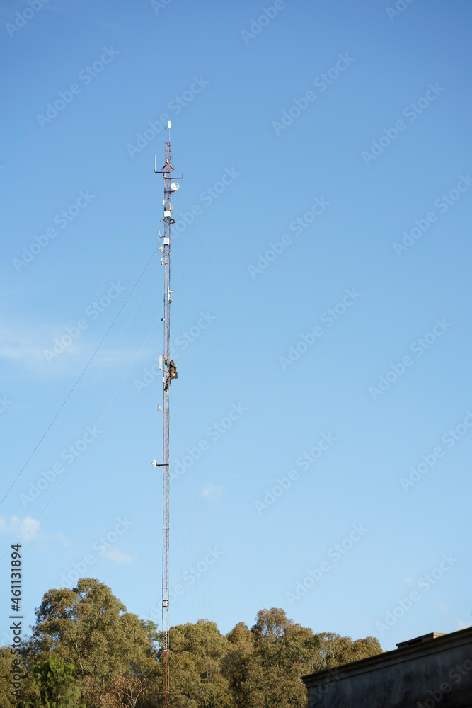 techmician on top of an internet provider tower doing maintenance