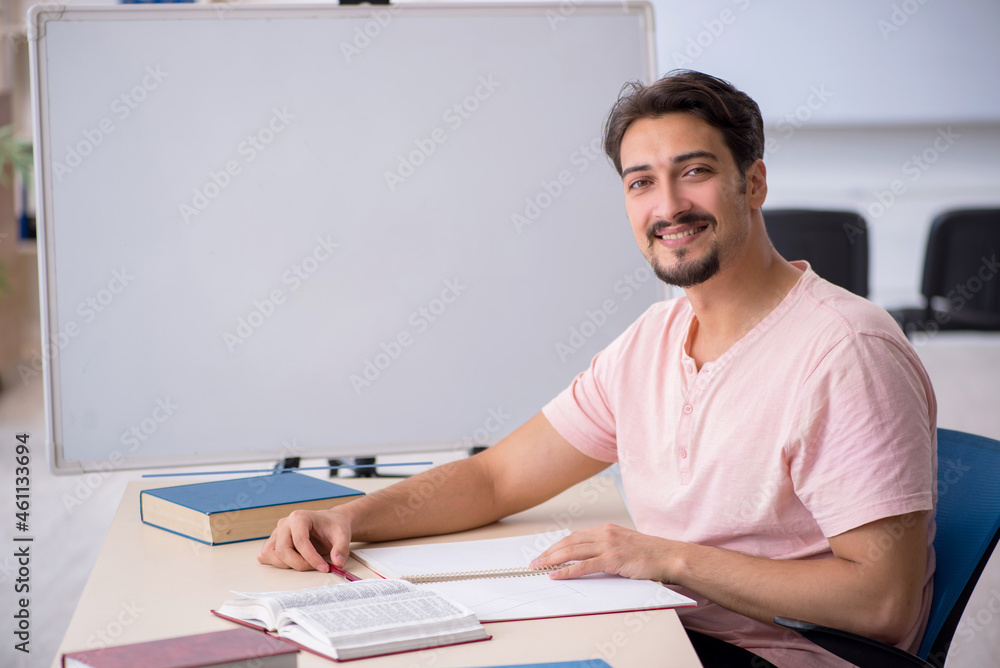 Young male student preparing for exams in the classroom Young male student preparing for exams in the classroom