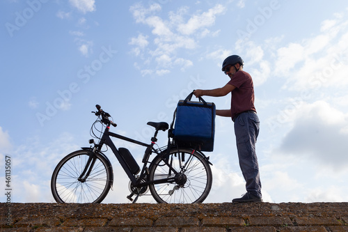 electric bicycle deliveryman preparing order for delivery
