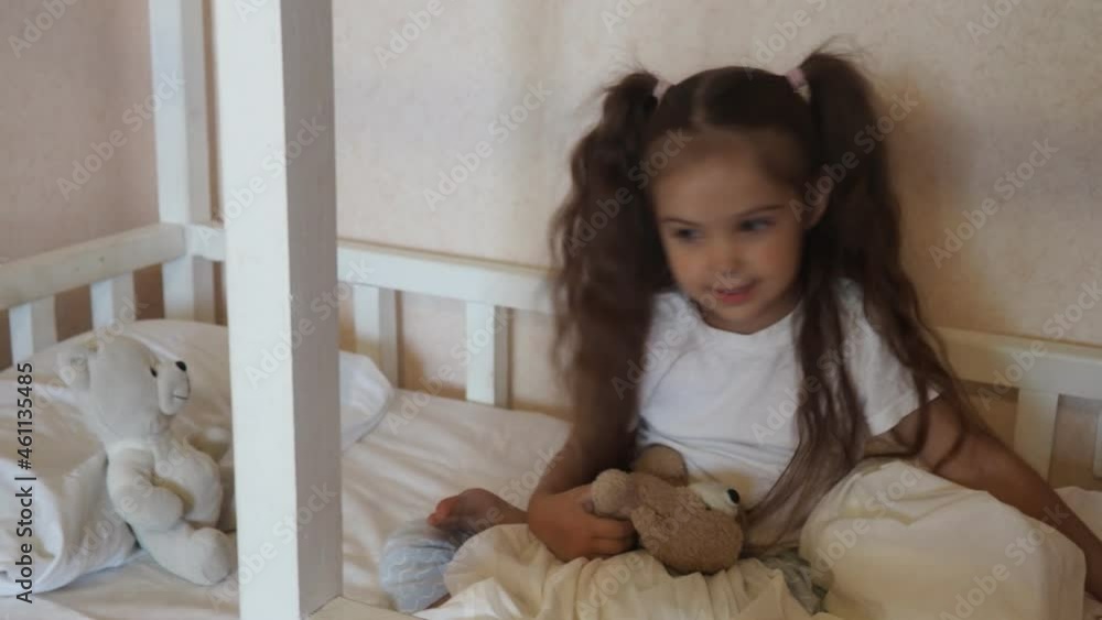 little cute girl is going to go to bed. indulges in, does not want to sleep. naughty. Cute little girl sleeping with teddy bear in bed little cute girl is going to go to bed. indulges in, does not want to sleep. naughty. Cute little girl sleeping with teddy bear in bed