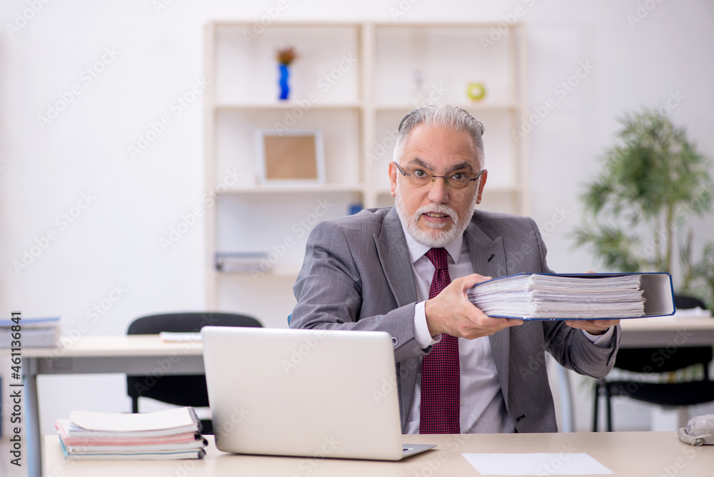 Old male employee working in the office Old male employee working in the office