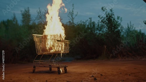 Burning boxes in a supermarket cart. Big fire in a metal trolley, last-minute shopping, best offer, sale promotion concept photo