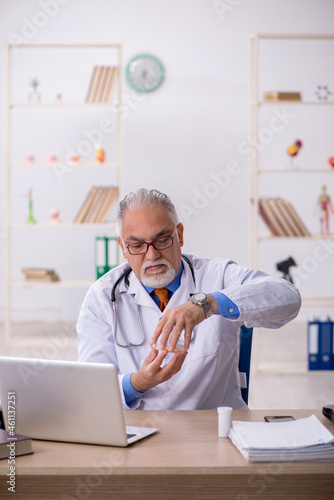 Old male doctor working in the clinic