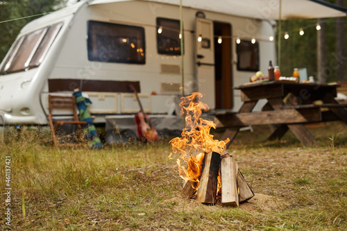 Print op canvas Background image of campfire in forest with trailer van in background, copy spac