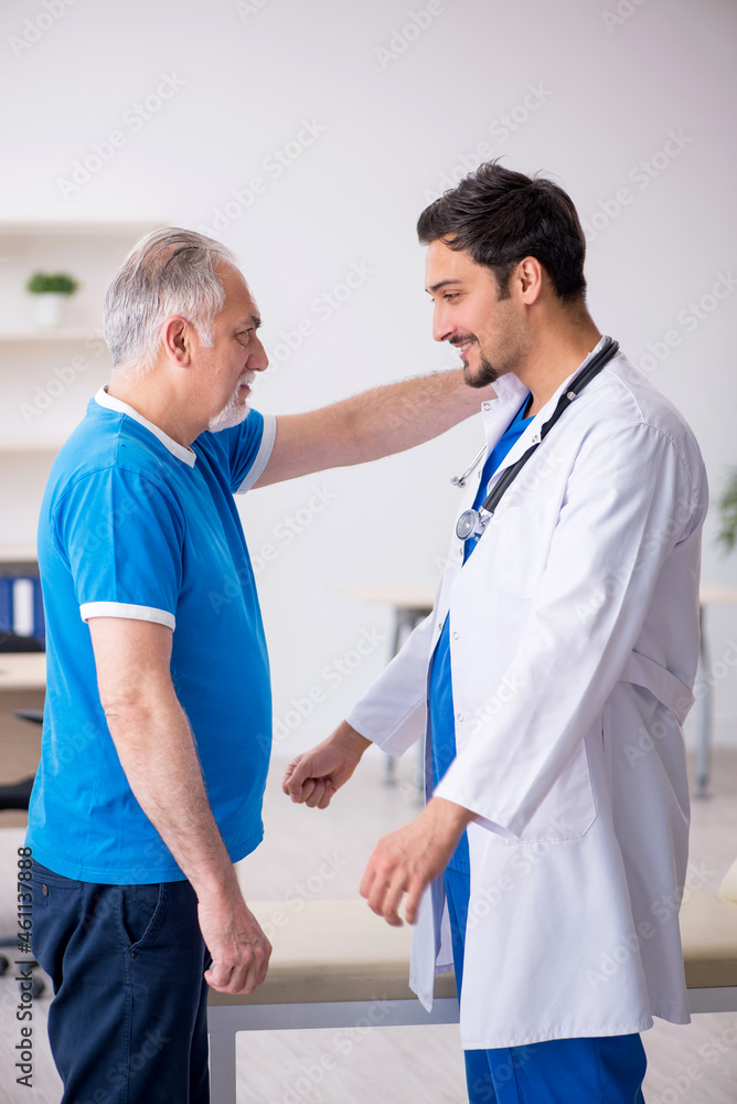 Fototapeta premium Old male patient visiting young male doctor
