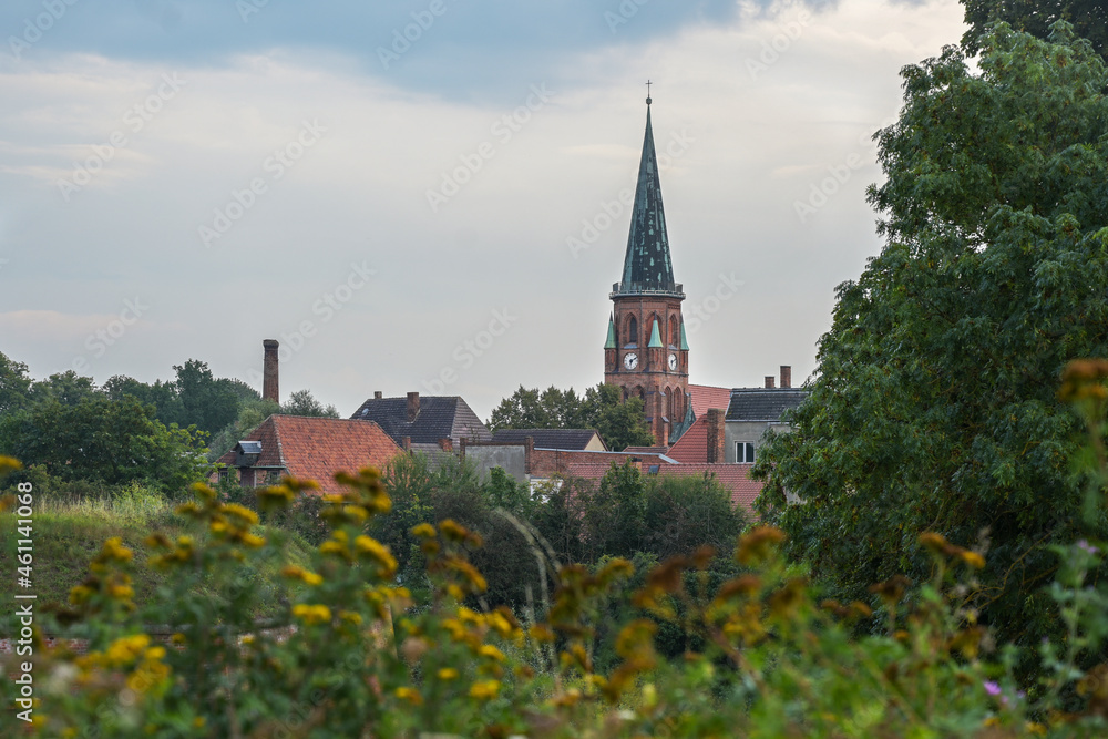 Church of the town Domitz against a cloudy sky in the green natural landscape on the river Elbe in northern Germany, Europe, copy space
