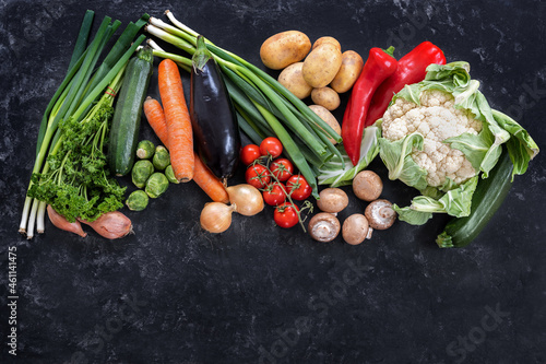 Fresh vegetables of different varieties on a dark slate background  diet food concept for fitness and lose weight  copy space  high angle view from above