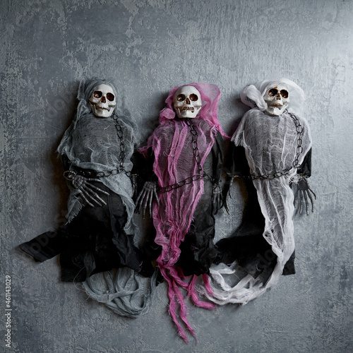 Halloween decoration three toy skeletons in colorful capes