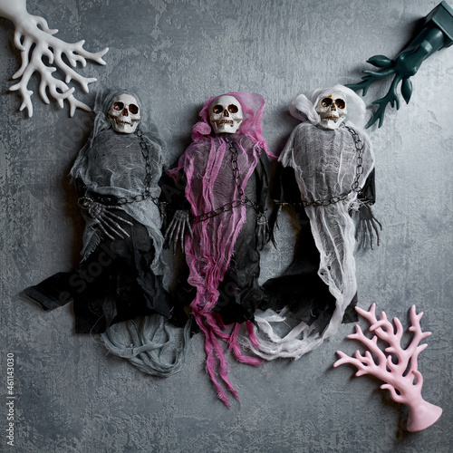 Halloween decoration three toy skeletons in colorful capes