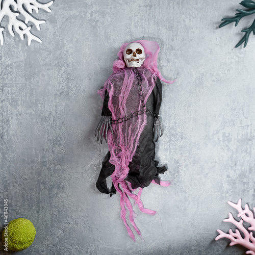 Halloween decoration a toy skeleton in black clothes and a torn cape