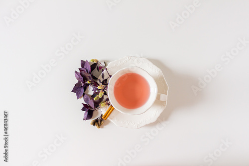 Cup of ginger tea composition with purple  pink on white background. Flat lay  top view. 