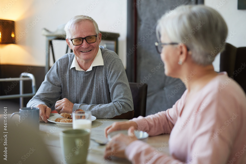 Portrait of white haired senior man smiling happily while enjoying breakfast in dining room at nursing home, copy space Portrait of white haired senior man smiling happily while enjoying breakfast in dining room at nursing home, copy space