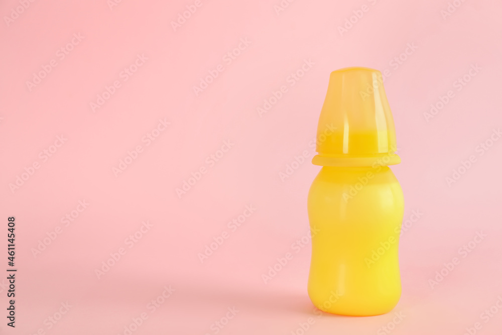 Feeding bottle with infant formula on pink background, space for text. Baby milk Feeding bottle with infant formula on pink background, space for text. Baby milk