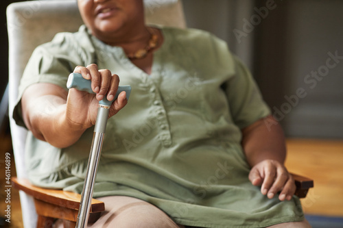 Cropped portrait of senior African-American woman holding cane in nursing home  copy space