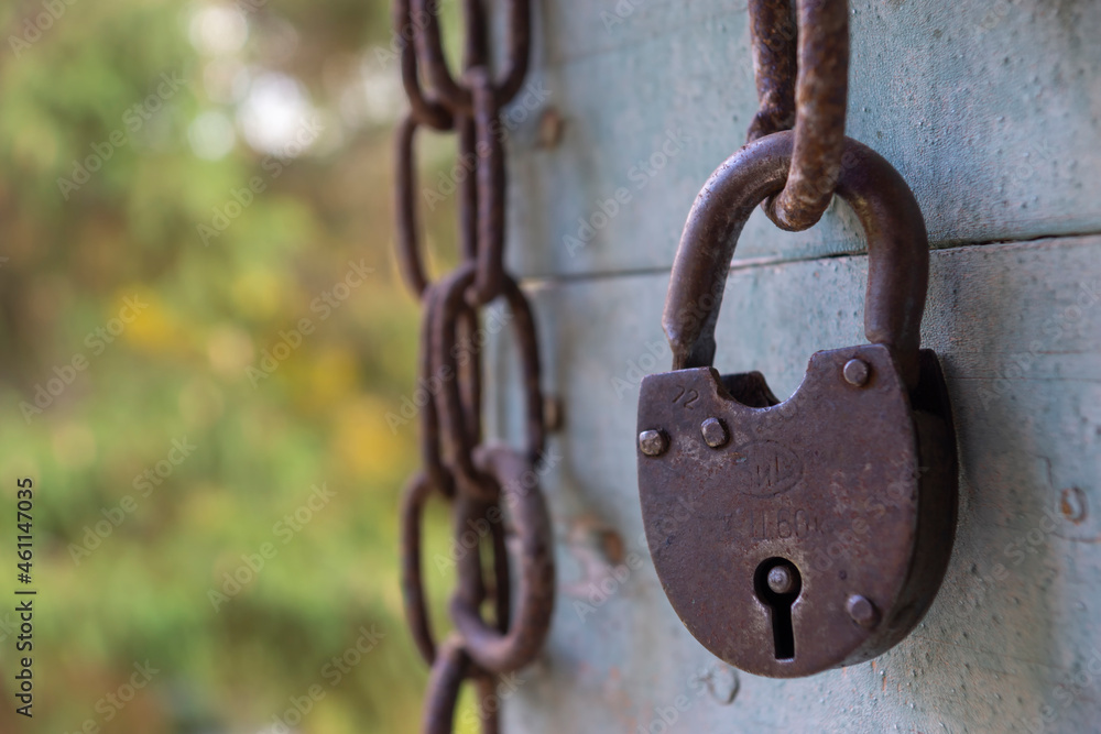 Old chain and metal lock on wood paneling