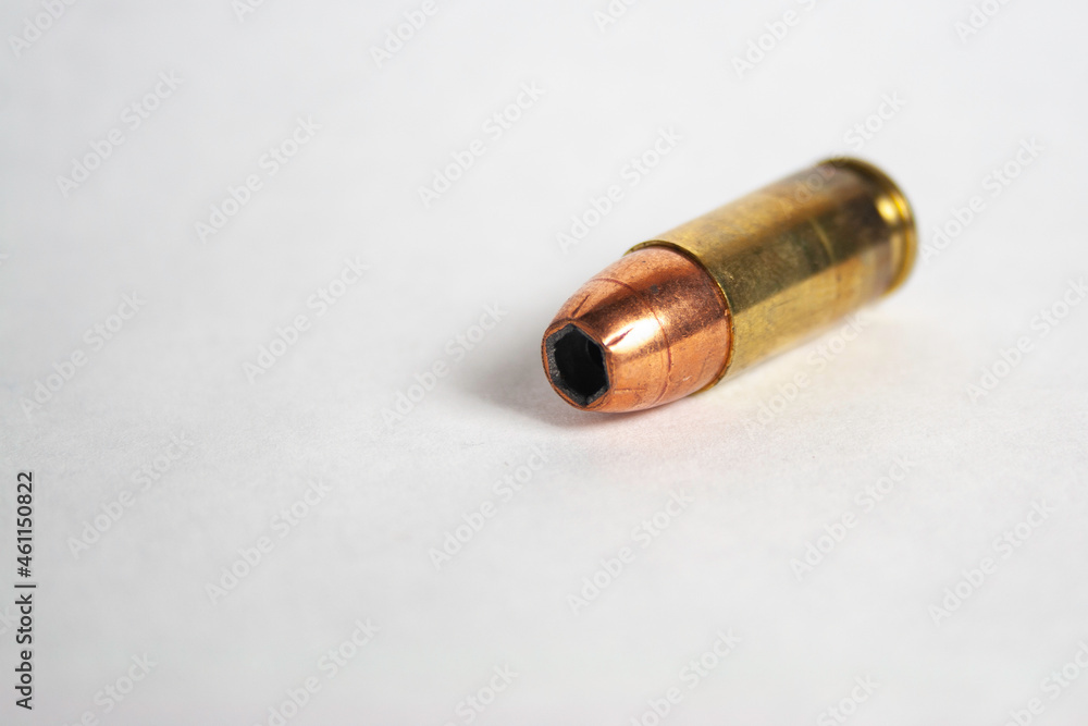 Single 9mm hollow-point cartridge on white background Single 9mm hollow-point cartridge on white background
