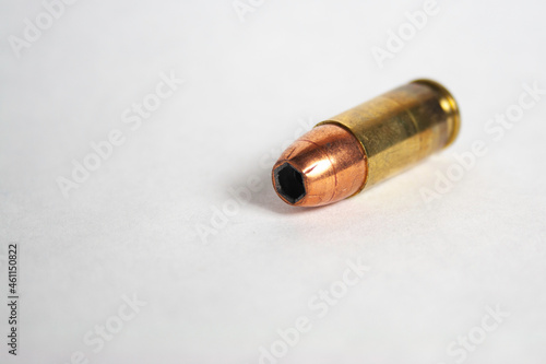 Single 9mm hollow-point cartridge on white background