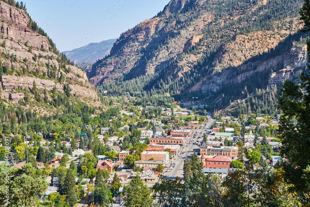 Fototapeta premium View of small town main road and completely surrounded by mountains