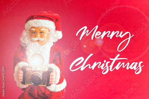 Santa Claus doll on red background. Santa Claus photographer. Merry christmas.