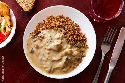 Popular Russian dish of beef stroganoff, made from finely chopped pieces of beef, filled with hot sour cream sauce, served ..with a side dish of buckwheat porridge