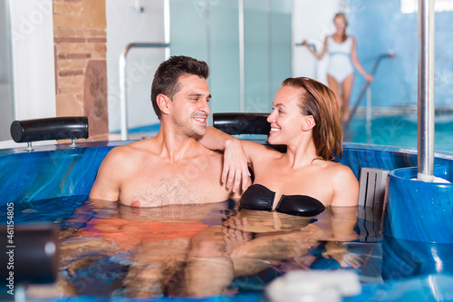 Couple is resting in a pool in time spa-day at the salon. Focus on both persons © JackF