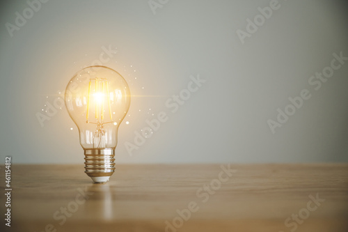 Obraz na plátne Light bulb on wood table with copy space