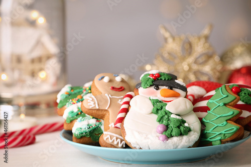 Sweet Christmas cookies on white table against blurred festive lights, closeup © New Africa